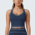 Detailopname van de donkerblauwe sportbeha met witte contrastbies voor fitness en training. - S / Tops / Embleem Blauw