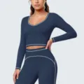 Detailoverzicht van de donkerblauwe sporttop en legging met elegante witte contrasterende bies. - S / Tops / Embleem Blauw