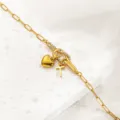 Edles Armband aus goldenem Edelstahl mit Herz Kreuz Anhängern und funkelnden Zirkonia Steinen. - Buchstabe T / Gold