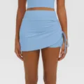 Detailed view of light blue athletic yoga skort with side ruching and high waist design. - S / Bottoms / Willow Blue