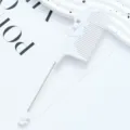 White plastic tail comb with cute bow design and metal pin for professional hair styling. - Bowknot Style / White