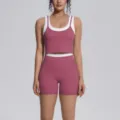 Detail view of the contrast color two-piece yoga set featuring a supportive crop top and shorts. - Violet
