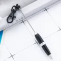 Mini keychain ballpoint pen, black and silver design, portable pocket writing tool variant. - Black