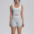 Detail view of stylish two-piece yoga set, featuring breathable elastic crop top and matching shorts. - Clay Grey