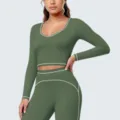 Close-up details van de naadloze sporttop met lange mouwen en leggings met witte contrastbiesen. - S / Tops / Rook Mos Groen
