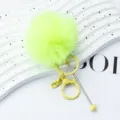 Fluffy neon green pom pom keychain with metal clasp and rod pendant for stylish bags. - Candy Yellow