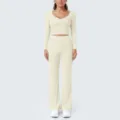 Detailansicht des nudefarbenen Langarm-Crop-Tops und der Schlag-Yogahose in Offwhite. - Hafer Aprikose