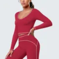Gedetailleerde opname van rode langearm sport crop top met witte contrastbiezen. - S / Tops / Kersenrood