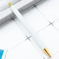 Witte en gouden metalen balpen met klikmechanisme, elegant en minimalistisch design voor kantoor. - Wit met gouden onderdelen