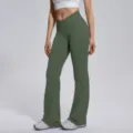 Detail shot of crossover high-waisted flare yoga pants in deep green, showing seamless texture. - S / Olive Green