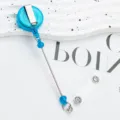 Porte-badge rétractable bleu avec design de perles, clip métallique et lanière transparente. - Bleu clair (transparent)