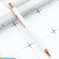 Minimalist metal ballpoint pen with white body and rose gold accents for office and school. - White