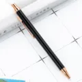 Minimalist black metal click ballpoint pen with rose gold trim for office and school daily use. - Black