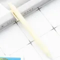 Retractable ballpoint pen in light yellow, smooth plastic writing stationery for student daily use. - Off White
