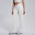 Detail view of white cross-waist flare yoga pants, showcasing stretchy fabric and flattering fit. - Feather Beige