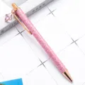 Pink glitter ballpoint pen with crystal clover pendant, rose gold metal trim, smooth writing. - Pink
