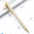 Gold glitter ballpoint pen with four-leaf clover pendant, elegant metal click pen for gift. - Gold
