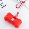 Red bone-shaped dog poop bag dispenser with carabiner and retractable cord for outdoor walking. - Red