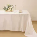 Vista dettagliata di elegante tovaglia in raso con finitura champagne liscia per matrimoni. - Bianco