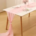 Detailed scene of pink chiffon table runner set on white dining table with wedding decor. - 70-600cm / Pink