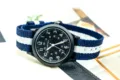 Detailed view of a black dial quartz watch with a blue white nylon strap and clear numbers. - Blue White Blue