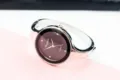 Detail view of women's fashion quartz bangle watch with dark dial and sparkling rhinestone markers. - Silver Black