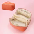 Large capacity PU leather woven cosmetic bag with compartments, stylish makeup organizer for women. - Vibrant Orange