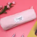 Pink corduroy cylindrical pencil pouch with cute alpaca label and zipper closure design. - Pink
