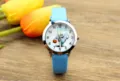 Detalle reloj cuarzo infantil, esfera fantasma Halloween, correa azul claro, manecillas. - Cian