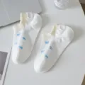 White short socks for women featuring cute blue bow prints and comfortable yellow ribbed cuffs. - One Size / White
