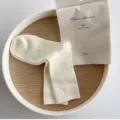 Cremeweiße gerippte Mittelsocken, feine Doppelnabenstrick-Textur, minimalistische Detailansicht. - Einheitsgröße / Creme