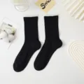 Black mid-calf women socks with ruffled white cuff and hollow diamond knit variant. - One Size / Black