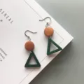 Close-up detail of geometric green triangle and brown round wood drop earrings texture - Hollow Green Triangle & Wood Circle Style (8)