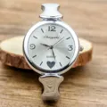 Women's silver stainless steel bangle quartz watch with minimalist dial and heart charm. - Silver White