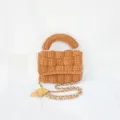 Detailed shot of handmade woven crochet handbag showing unique textured pattern and chain strap. - Caramel color