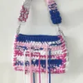 Handmade crochet shoulder bag detail showing multi-color fabric strips and metal chain. - Pale Blue
