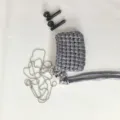 Detailed shot of handmade silver woven earphone case with metal chain and heart charm. - Dark Gray