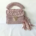 Handmade metallic yarn crochet shoulder bag with stylish turn lock and elegant tassel charm. - Light Pink
