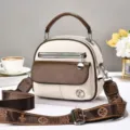 Detail van de retro crossbodytas in wit en bruin met patroon schouderband en metalen ritsen. - Broken Wit