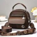 Bruine vintage schoudertas voor dames met handvat, meerdere vakken en stijlvolle monogram schouderband. - koffiekleur