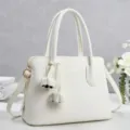 Detail view of the elegant white pebbled leather handbag with double handles and gold hardware. - L 31cm, W 14cm, H 22cm, Handle 17cm / Off White