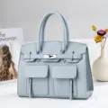Sac a main en cuir bleu clair avec poches avant et serrure argentees pour le travail quotidien. - Bleu clair