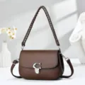Détail de sac à bandoulière en cuir marron, poignée chaîne tressée et fermoir métallique. - 20/8/14 / Café