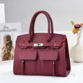 Vue détail du sac à main bordeaux élégant avec poches avant et serrure métallique chic. - Rouge