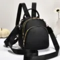 Détail de mini sac à dos noir montrant des fermetures éclair dorées et des bretelles. - 19x9x20cm / Noir