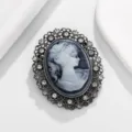 Primer plano detallado de broche camafeo vintage, montura filigrana plateada con pedrería brillante. - Estilo F / Gris