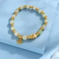 Chinese dragon year beaded bracelet detail, elegant green beads with golden charms and fu tag. - White