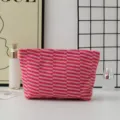 Detail view of the pink and red striped knitted cosmetic pouch, showcasing soft texture and pattern. - Red Stripe