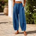 Outdoor lifestyle shot of blue loose-fitting harem pants with pleated front details. - Sapphire Blue