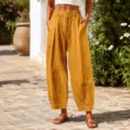 Detailed macro view of mustard yellow cropped harem pants with textured linen fabric. - Sunflower Yellow